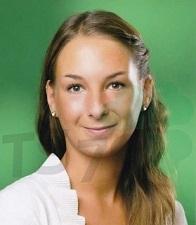 Porträt einer lächelnden Frau mit langen, braunen Haaren vor einem grünen Hintergrund. Sie trägt ein weißes Oberteil.