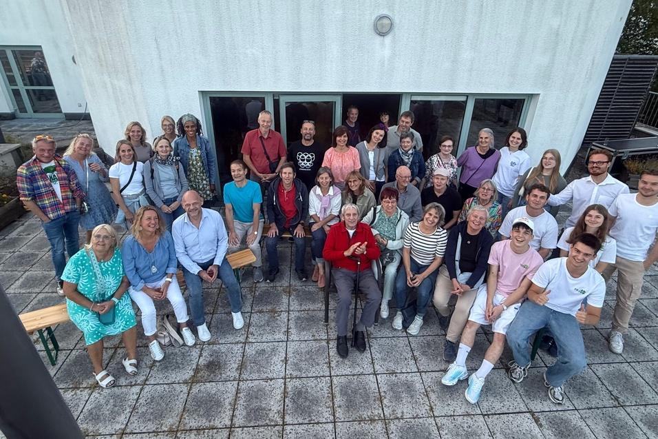 Gruppenfoto von 36 Personen, die vor einem modernen Geb&auml;ude auf einer Terrasse stehen.